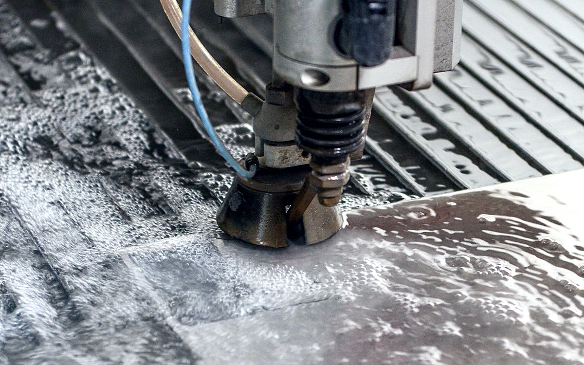 Cabezal de Waterjet cortando placa metálica